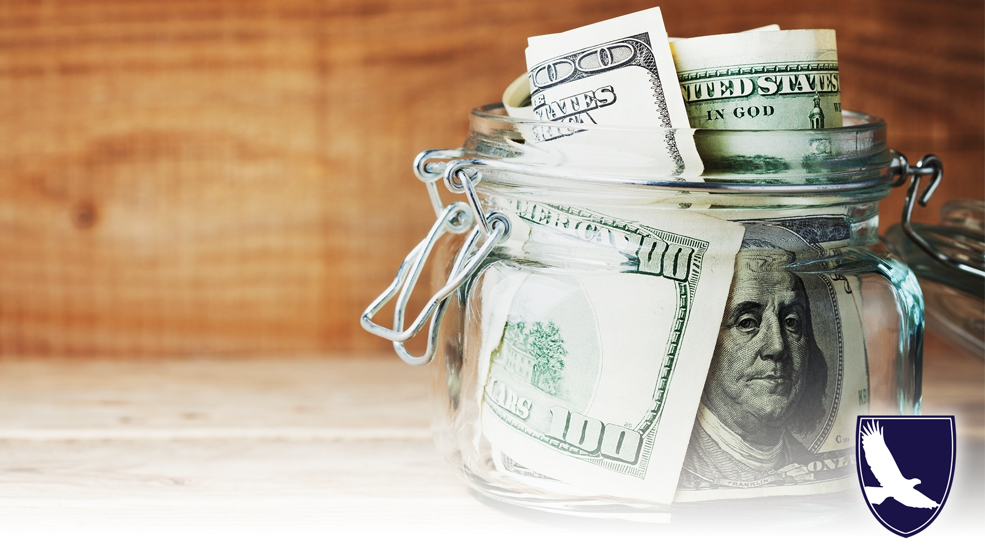 Dollar bills in glass jar on wooden background. Saving money concept.